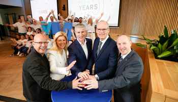 Corporate offsite event with Irish business leaders celebrating 10 year anniversary surrounded by team members at a modern venue in Ireland