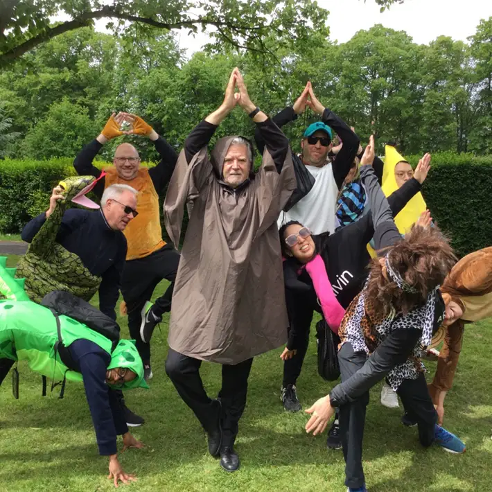 A dramatic and theatrical group photo of participants in a mix of jungle and mystical costumes, all embracing the survival challenge with enthusiasm and humor.