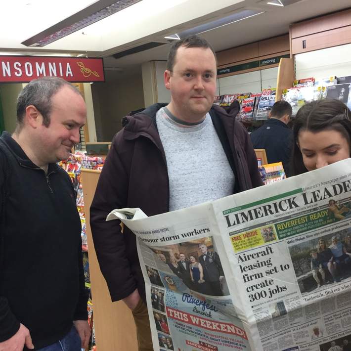 posing with a newspaper ina shop