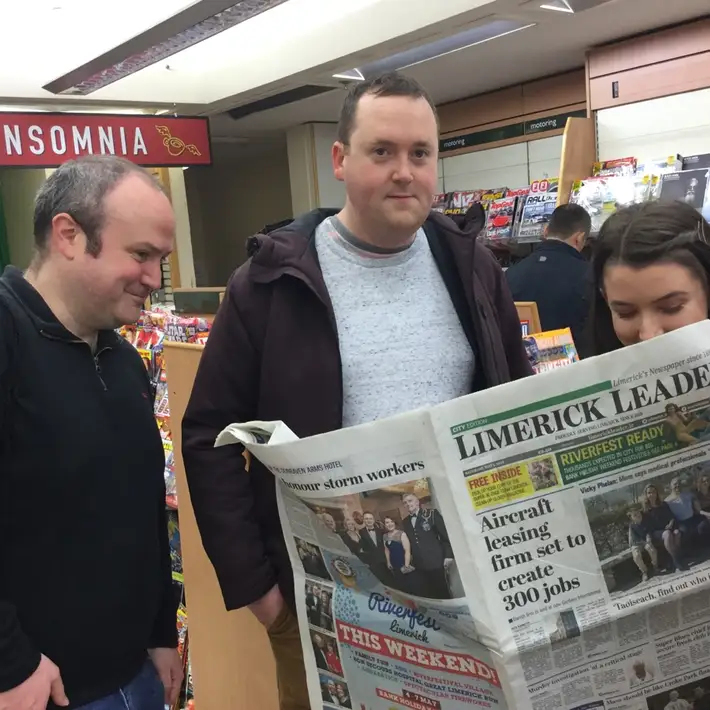 posing with a newspaper ina shop