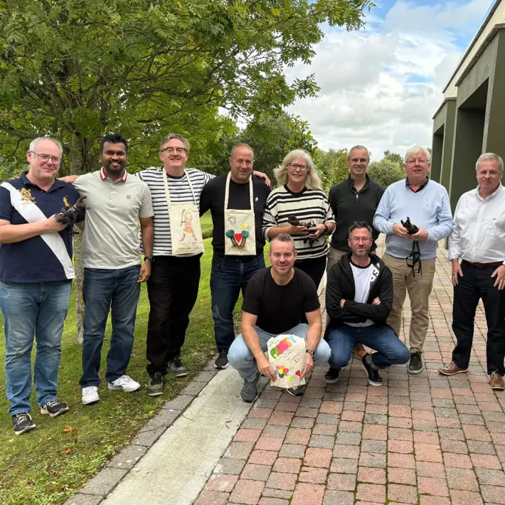 Corporate team in Ireland completing The Hand Project CSR team building activity, assembling prosthetic hands and showcasing decorated donation bags.