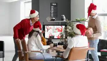 Corporate team enjoying a hybrid virtual Christmas party with festive decorations