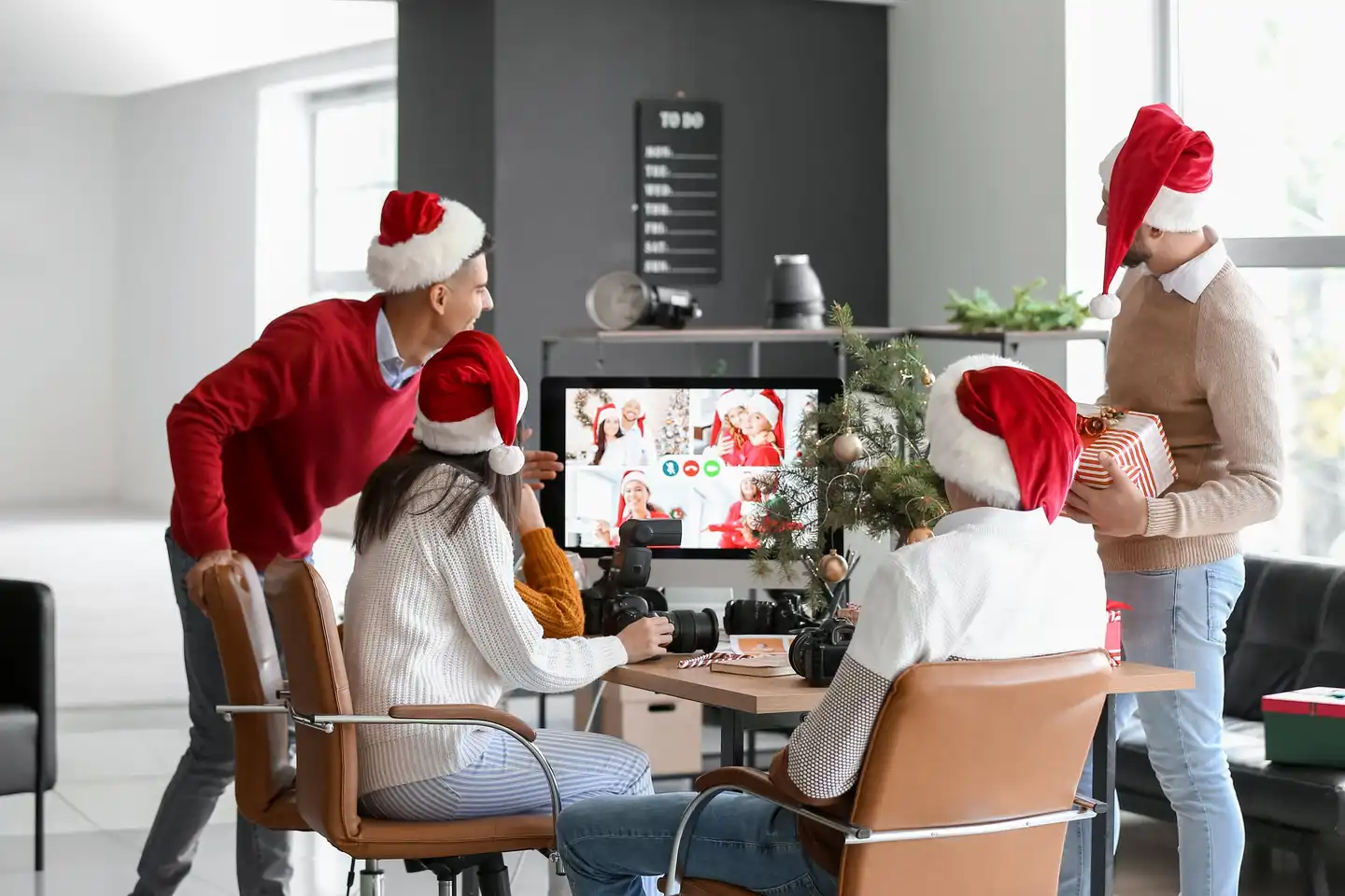 Corporate team enjoying a hybrid virtual Christmas party with festive decorations
