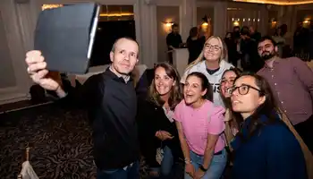 Team participating in a remote-hosted digital treasure hunt in Ireland, using a tablet to complete challenges during a corporate team building event.