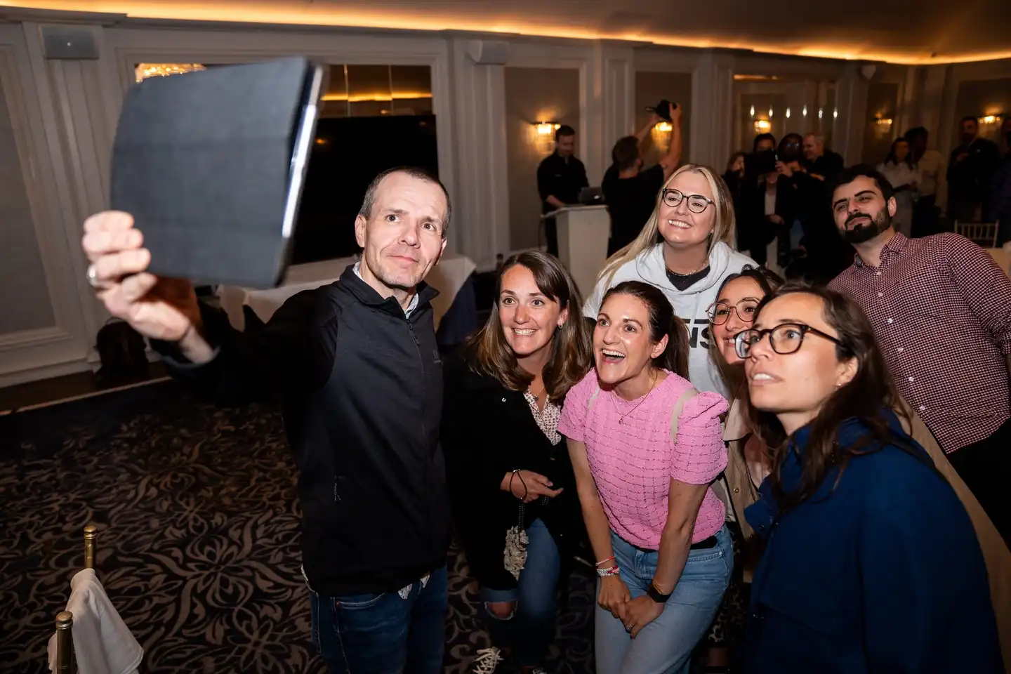 Team participating in a remote-hosted digital treasure hunt in Ireland, using a tablet to complete challenges during a corporate team building event.