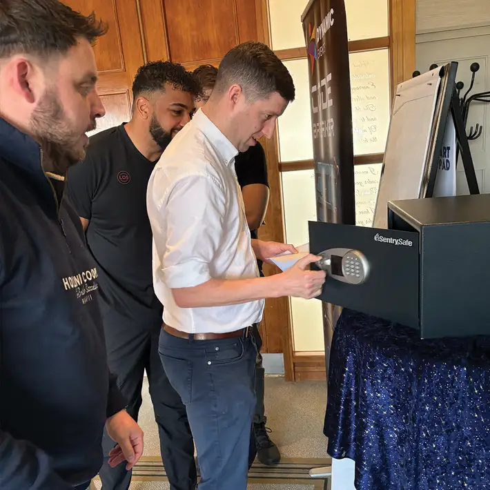 Senior leadership team solving Code Breaker challenge during corporate team building activity in Ireland