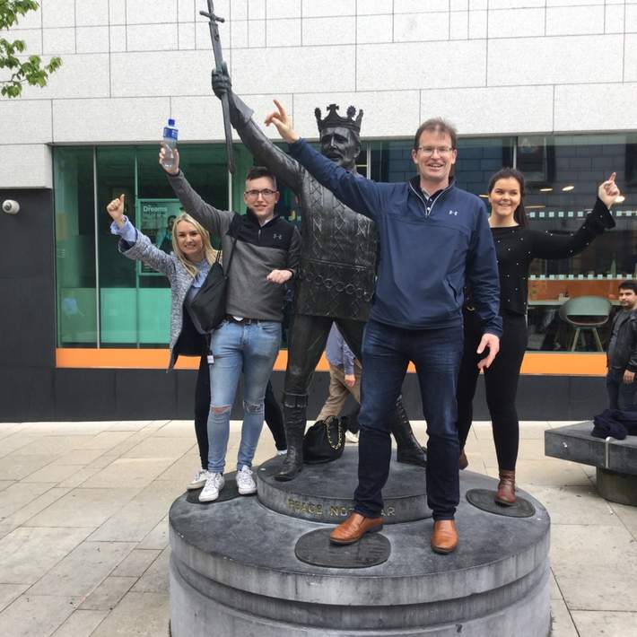people posing with a statue