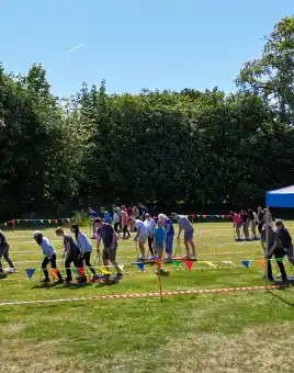 College staff taking part in an outdoor team building challenge with Dynamic Events, featuring group activities, colourful bunting, and branded tents on campus grounds in Ireland.