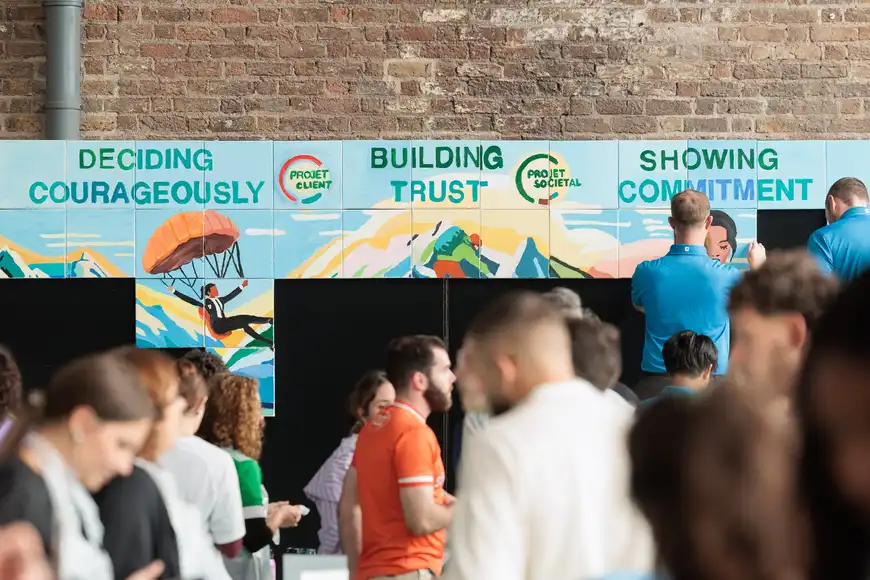 Corporate participants adding vibrant colours to a shared canvas in a creative indoor team building session.