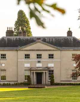 Avondale House pictured through the trees on a plain of grass