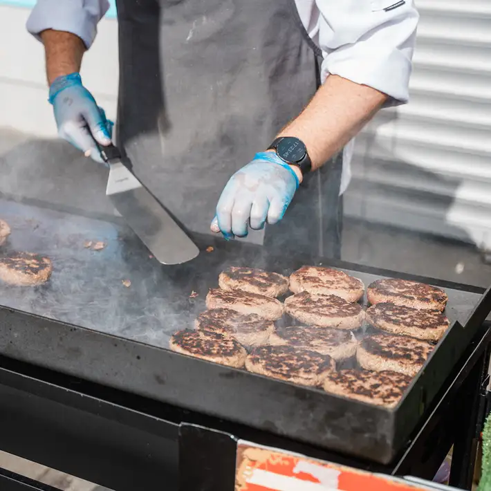 BBq Burgers being fried by a chef