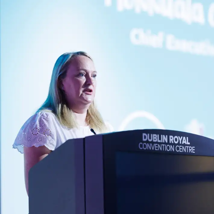 CHF MD presenting to the corproate participants about why they are there on top of a stage