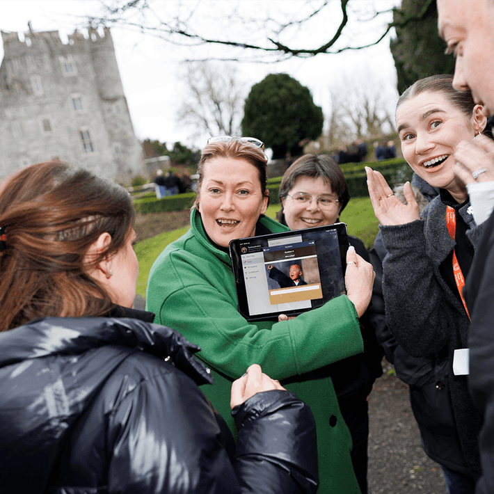 Corporate team enjoying a Venue Adventure digital treasure hunt on hotel grounds in Ireland, using an iPad to complete GPS challenges