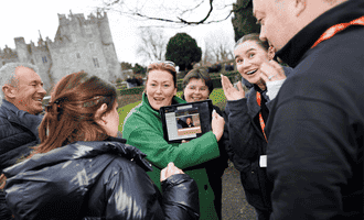 Corporate team enjoying a Venue Adventure digital treasure hunt on hotel grounds in Ireland, using an iPad to complete GPS challenges