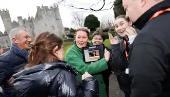 Corporate team enjoying a Venue Adventure digital treasure hunt on hotel grounds in Ireland, using an iPad to complete GPS challenges