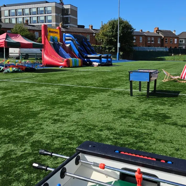 Foosball table in the corner and big inflatable activities in the background. for the teenagers at the corporate family day event