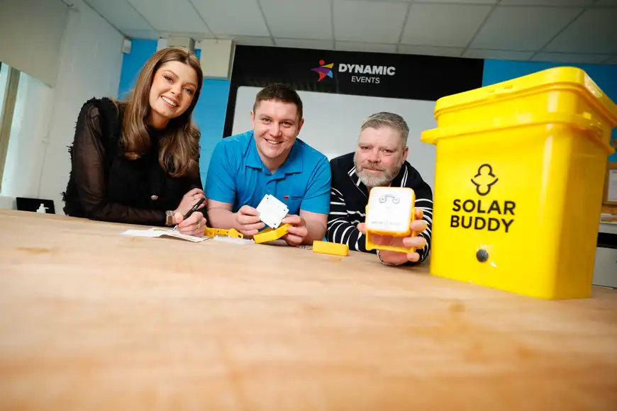 Three colleagues building SolarBuddy lights during a corporate team building activity with Dynamic Events in Ireland