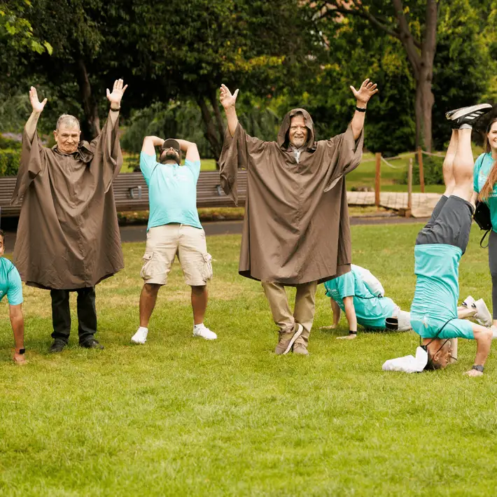 Teams reach actors and pose for a yoga task 