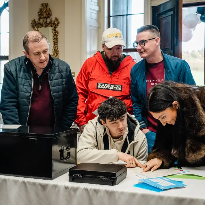 Corporate team taking part in Code Breaker activity during anniversary celebration