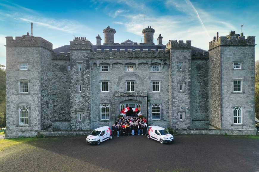 Happy team outside slane castle doing a team building activity as part of their kick off