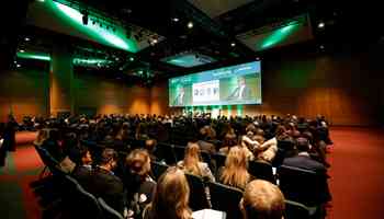 Corporate kick-off event with a large audience attending a keynote presentation in a modern conference venue in Ireland.
