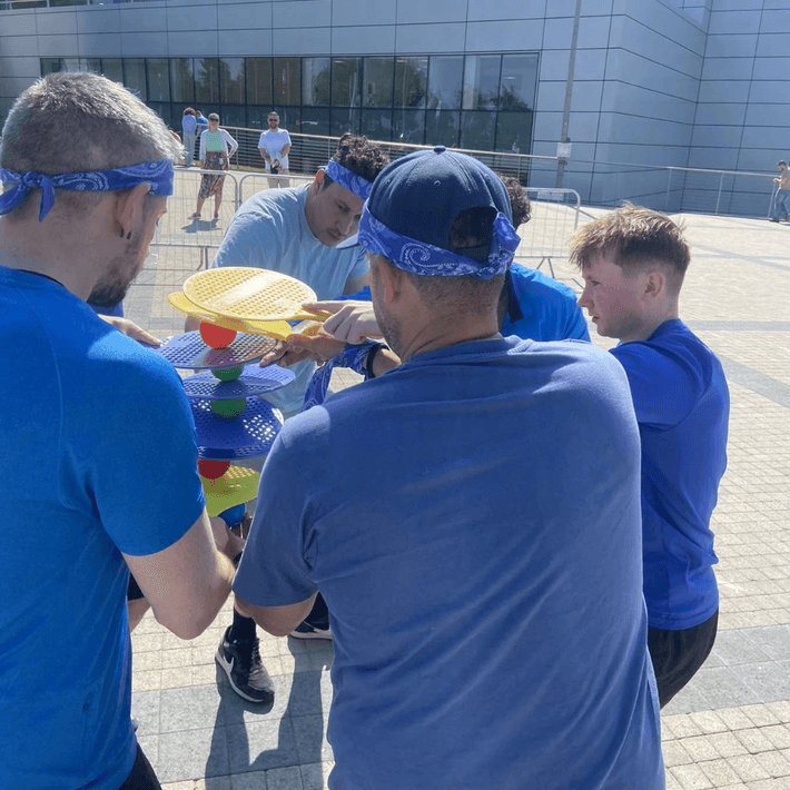 Blue team collaborating during a game of bat and ball