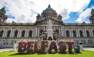 Queens university Belfast with big building and a flower sign saying belfast outside | Team Training Belfast