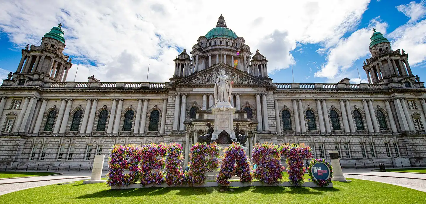 Queens university Belfast with big building and a flower sign saying belfast outside | Team Training Belfast
