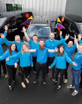 Dynamic Events Ireland team standing together in front of branded vans, showcasing team building and event management services in Dublin and ireland.