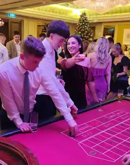 Guests enjoying a corporate Christmas casino night with roulette and festive decorations in Ireland.