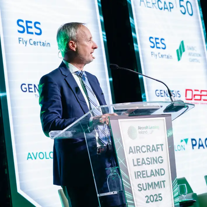 Man talking at the conference on the stage infront of microphone