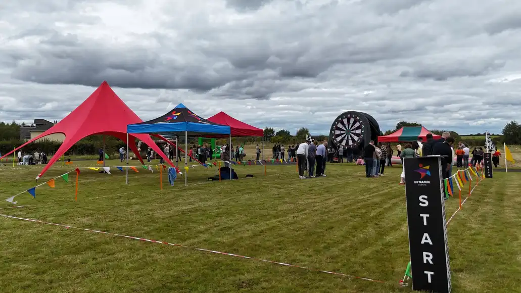 Outdoor team building event with large inflatables and marquees with people enjoying the weather and the corporate activities | County Kerry