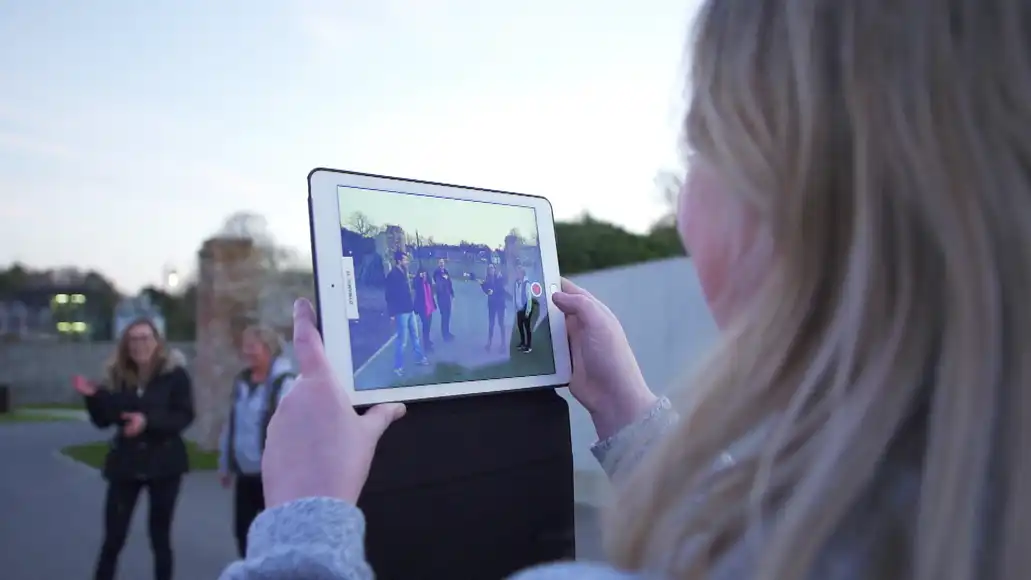 Corporate group in an outdoor setting filming a scene as part of a creative treasure hunt challenge