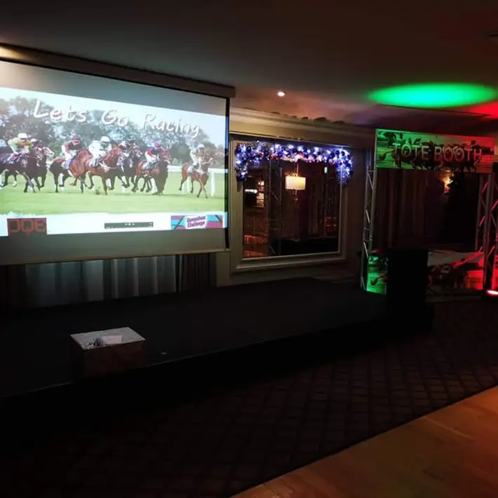 Big screen showing a horse race during a corporate Race Night