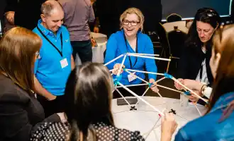 Corporate team building activity in Carlow with colleagues collaborating on a hands-on workshop indoors