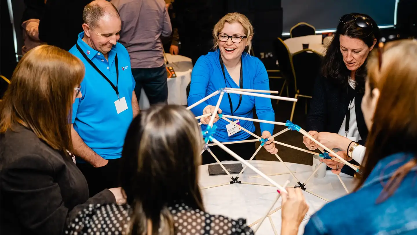 Corporate team building activity in Carlow with colleagues collaborating on a hands-on workshop indoors