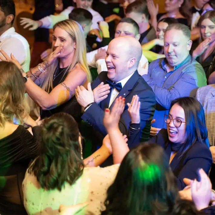 happy team doing dance during disco bingo team building activity evening entertainment