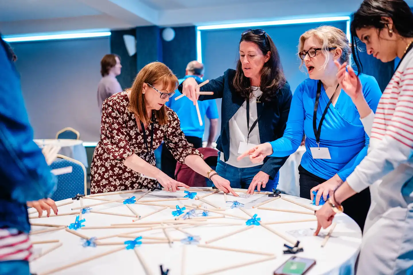 Senior leadership team participating in a hands-on team development activity during a leadership retreat in Ireland, focused on collaboration and problem-solving.