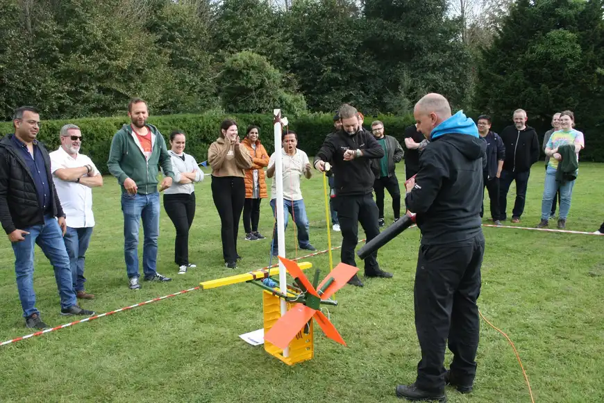 Corporate team building outdoors with wind turbine challenge during sustainability event in Ireland