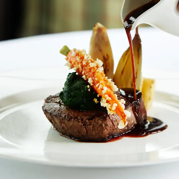 New tasting menu at trump international ireland beef with a carrot on top and gravy getting poured on top