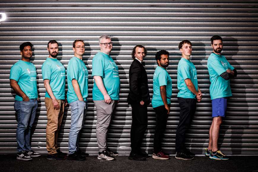Team in matching shirts with undercover agent during Spy Squad team building challenge