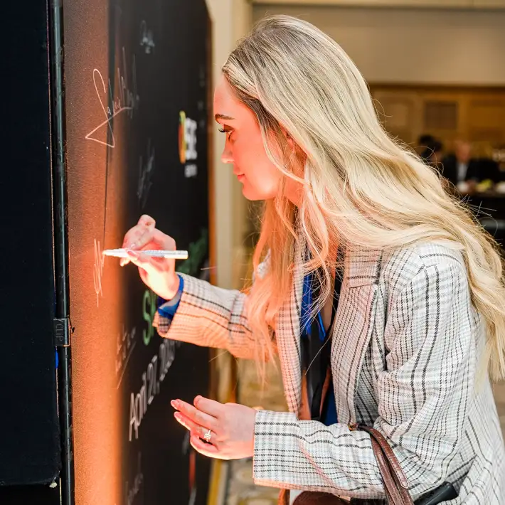 Delegate signing signature wall at company away day networking event