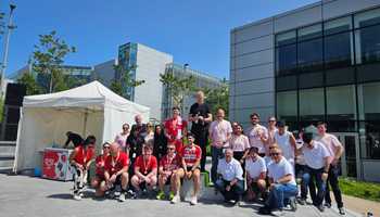 Winners on podium holding medals and sweets at Apple’s summer sports day