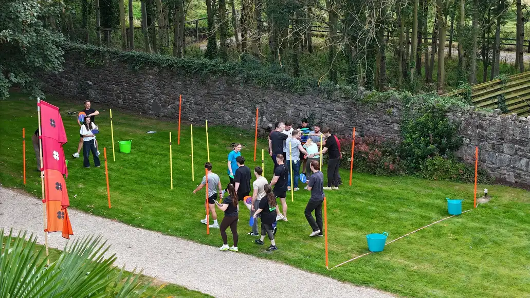 An outdoor events which shows teams working together to get across the finish line while also taking shade in the trees | County Kerry