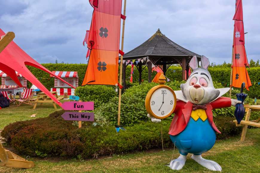 Alice in Wonderland themed family fun day at a corporate event, featuring the White Rabbit statue with clock, colourful tents, and outdoor games in Laois Ireland.