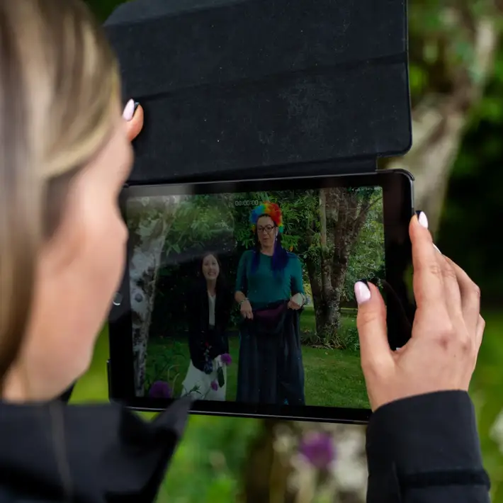 woman taking video of people completing tasks through the ipad 