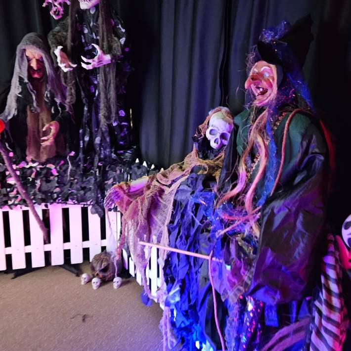 White fence with witch and spooky skeletons 