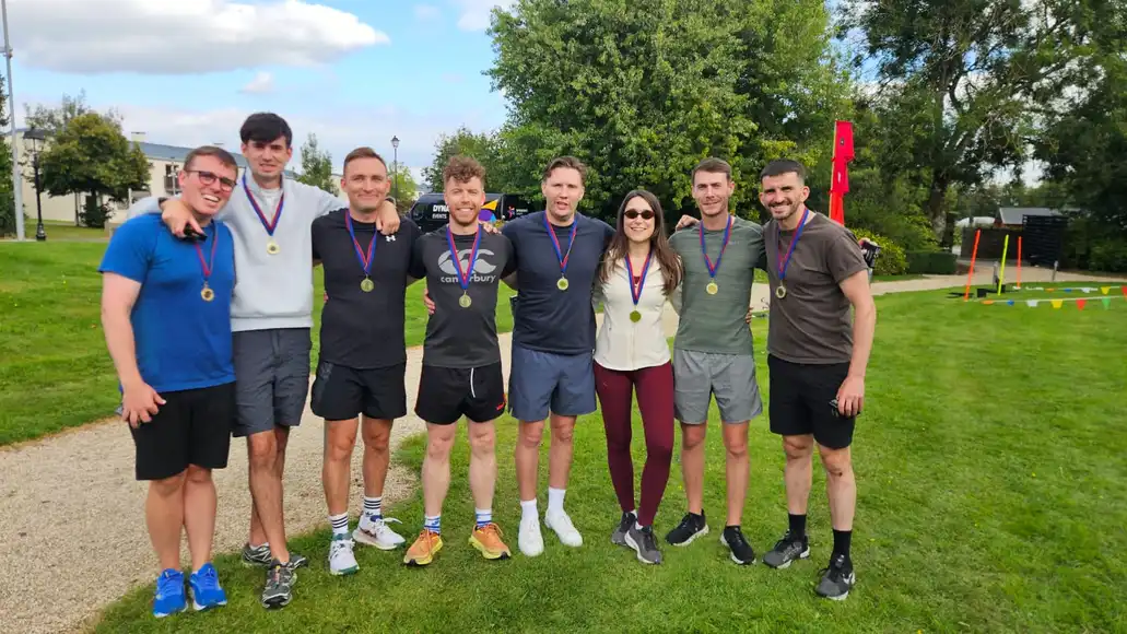 College staff team celebrating after a team building activity with medals in Ireland.