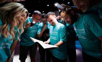 Corporate team building activity in Ireland with colleagues collaborating during a challenge at an indoor event
