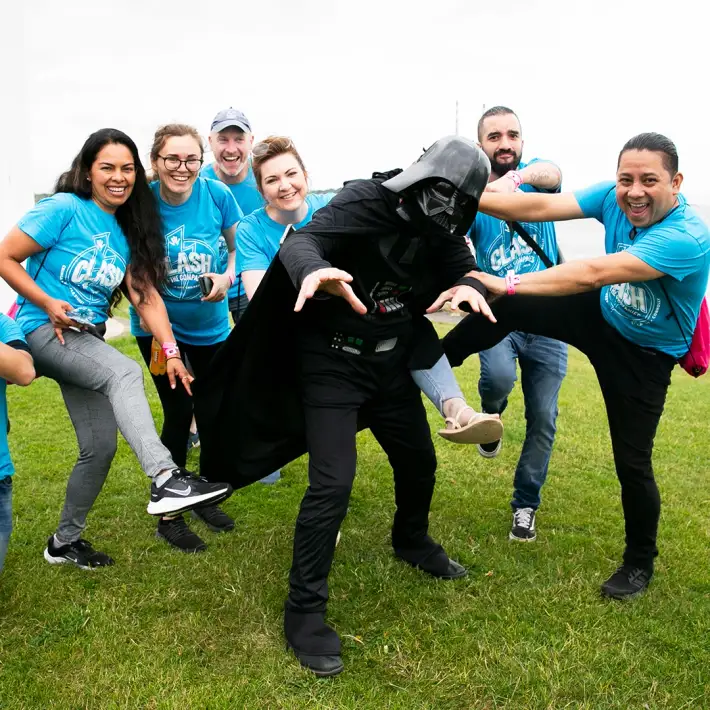 Corporate group posing with Darth Vader character during a Dynamic Events Space Survival team building activity by the sea in Dublin, Ireland.